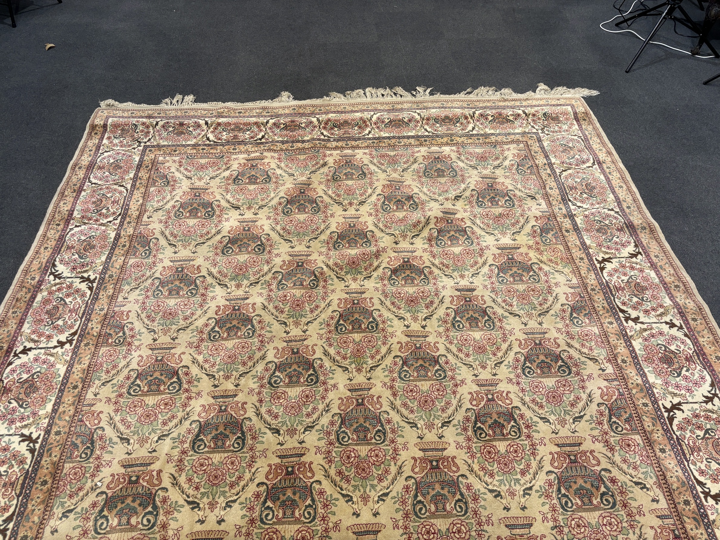 A North West Persian ivory ground carpet, woven with rows of flowering urns, 400 x 298cm